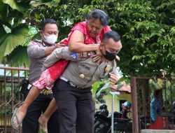 SEORANG NENEK DI GENDONG AKP HENDRIK KE TEMPAT VAKSINASI LANSIA.