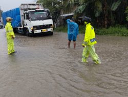 Walau Cuaca Hujan Personel Polsek Perdagangan Pengamanan Dijalan Rusak Penuh Dengan Genangan Air